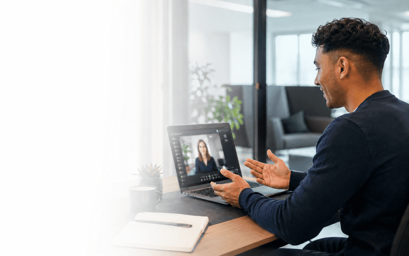 A recruitment consultant on a video call, taking notes at their desk